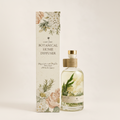 Light Art Botanical Home Diffuser set featuring a clear glass bottle with botanical elements inside and a tall decorative box with floral illustrations, photographed on a warm off-white background.